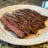 Deliciously marinated and grilled flank steak with juicy marinade dripping.