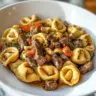 Delicious Philly Cheesesteak Tortellini Pasta topped with cheese and peppers