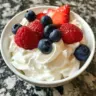 Bowl of refreshing Greek yogurt jello fluff dessert topped with berries