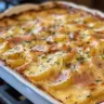 Baked scalloped potatoes with ham in a creamy sauce, topped with cheese