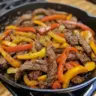 Delicious skillet steak fajitas served with colorful bell peppers and onions