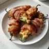 Bacon-wrapped jalapeño poppers stuffed with cheese, ready to be served as a spicy appetizer.