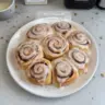 Delicious homemade cinnamon rolls topped with icing on a wooden table