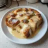 Delicious bread pudding drizzled with creamy vanilla sauce