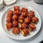 Brown sugar bacon wrapped pineapple bites on a serving platter