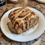 Freshly baked Cinnamon Roll Banana Bread with swirls of cinnamon glaze
