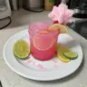 Colorful Cotton Candy Margarita in a glass, garnished with cotton candy and lime.