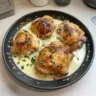 Creamy garlic parmesan chicken thighs served on a plate with herbs