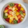Easter Fruit Salad topped with Peach Pie Filling in a colorful bowl