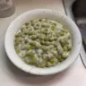 Creamed peas dish served in a bowl, garnished with herbs.