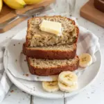 Slice of easy moist banana bread on a wooden cutting board