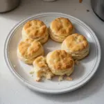 Freshly baked fluffy homemade biscuits on a kitchen counter.