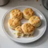 Freshly baked fluffy homemade biscuits on a kitchen counter.