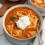 Bowl of gluten free lasagna soup topped with basil and melted cheese