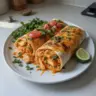 High protein low calorie cheesy buffalo chicken burritos on a plate