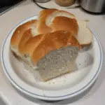 Freshly baked homemade Amish white bread on a wooden table.