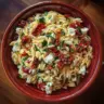 Homemade orzo pasta salad with feta cheese and sun-dried tomatoes in a bowl.