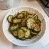 Delicious Korean Cucumber Salad garnished with fresh herbs and spices.
