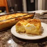 Lemon cream cheese dump cake topped with fresh lemon slices and whipped cream