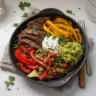 Delicious low carb steak fajita bowl with fresh vegetables and seasonings