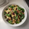 Nutritious spinach pasta salad with feta cheese and cranberries served in a bowl