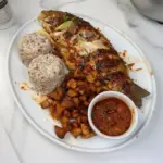 Delicious Ofada Sauce served with fish and rice on a plate