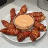 Oven baked bacon wrapped chicken tenders served on a plate