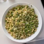 Plate of pasta and peas garnished with herbs and cheese