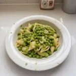 Delicious pasta with peas garnished with herbs on a plate