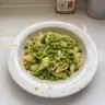 Delicious pasta with peas garnished with herbs on a plate