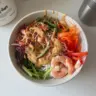 Spring Roll Bowl topped with creamy peanut dressing and fresh vegetables