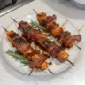 Delicious sweet potato skewers with bacon on a platter