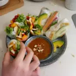 Colorful vegan summer rolls with fresh vegetables and herbs on a plate