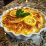 Delicious zesty lemon cobbler served in a white dish with a golden crust.