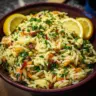 Zesty lemon orzo pasta salad in a bowl with fresh ingredients