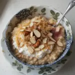 Delicious Almond Croissant Oats with almond slices topped with fresh fruits.