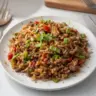 Delicious ground venison dirty rice served in a bowl with fresh herbs
