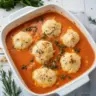 Bowl of best tomato soup with cheddar bay dumplings on a wooden table