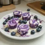 Blueberry swirl yogurt bites in a bowl with fresh blueberries