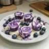 Blueberry swirl yogurt bites in a bowl with fresh blueberries