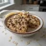 Bowl of chunky monkey banana baked oatmeal with banana slices and nuts