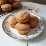 Freshly baked cinnamon muffins on a wooden table