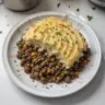 Classic ground venison shepherd's pie served on a rustic table