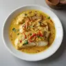 Plate of coconut curry baked cod garnished with fresh herbs