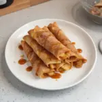 Crispy air fryer apple pie taquitos served with cinnamon and caramel sauce