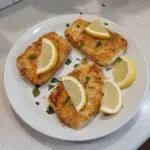 Delicious air fryer cod fish served with lemon and herbs