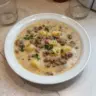 Bowl of delicious hamburger potato soup with fresh toppings