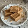 Delicious homemade peanut butter fudge squares on a white plate