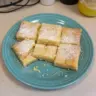 Delicious 2-ingredient lemon bars on a wooden plate