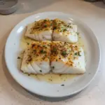 Deliciously baked cod fillet garnished with herbs and spices